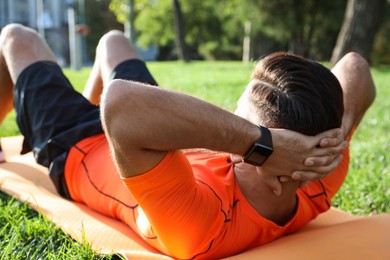 Man wearing fitness tracker during training in park