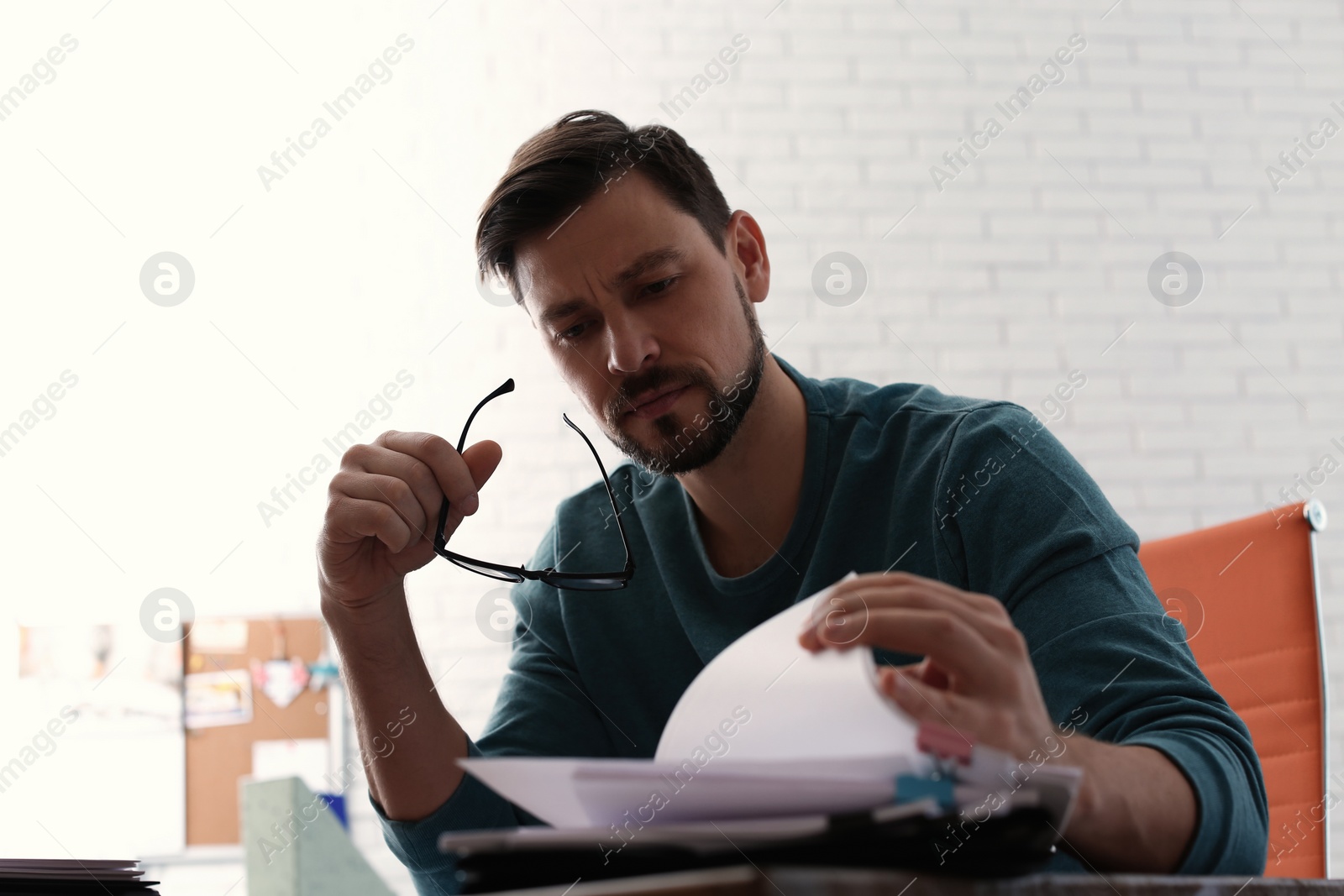 Photo of Man working with documents at table in office