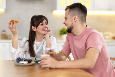 Photo of Happy couple having tasty breakfast at home