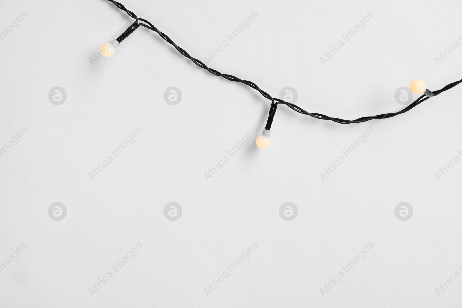 Photo of Beautiful Christmas lights on white background, top view