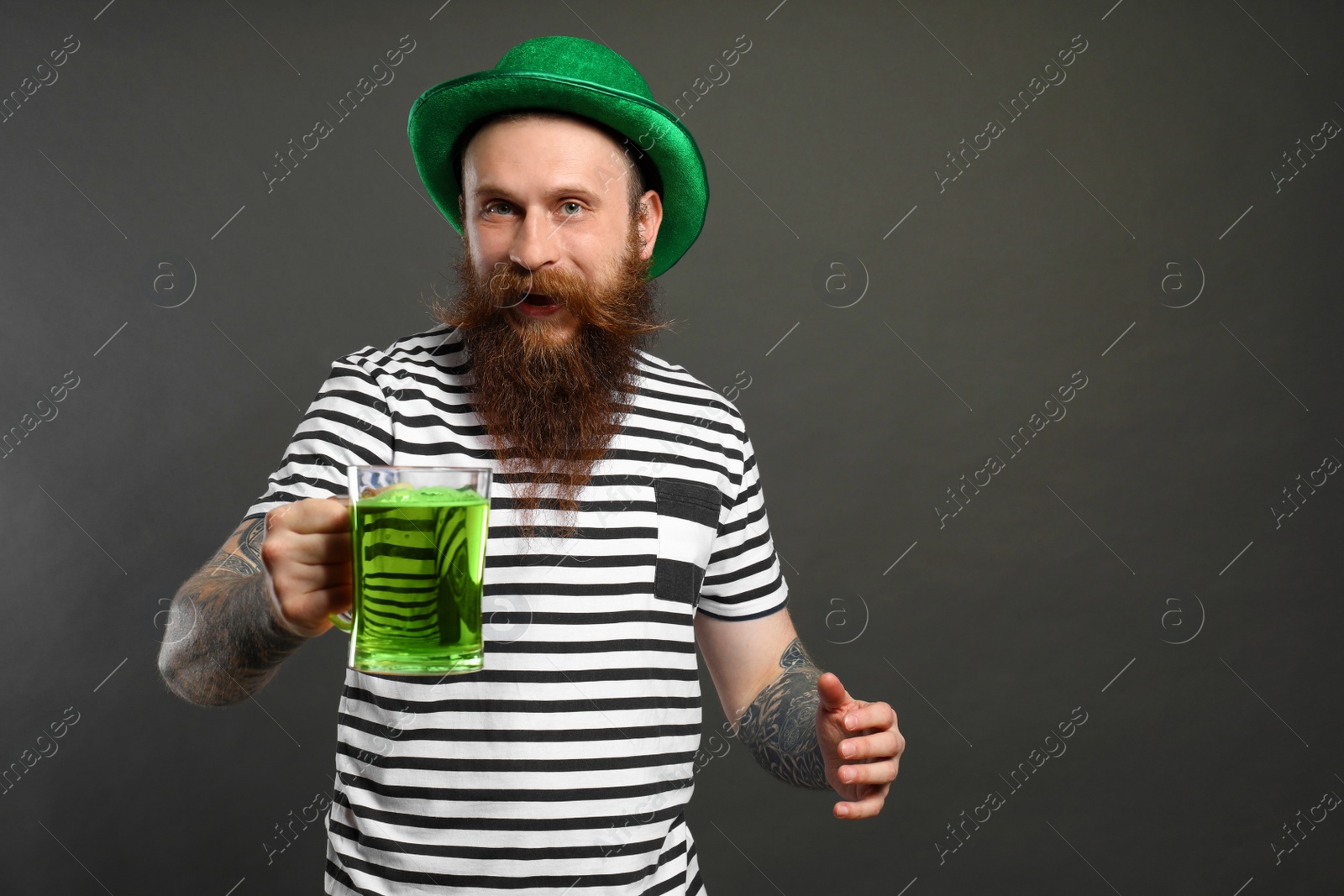 Photo of Bearded man with green beer on grey background. St. Patrick's Day celebration