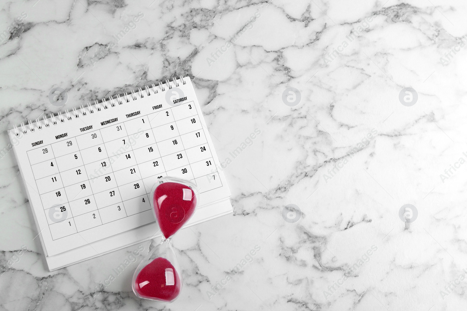 Photo of Calendar and hourglass on white marble background, flat lay. Space for text