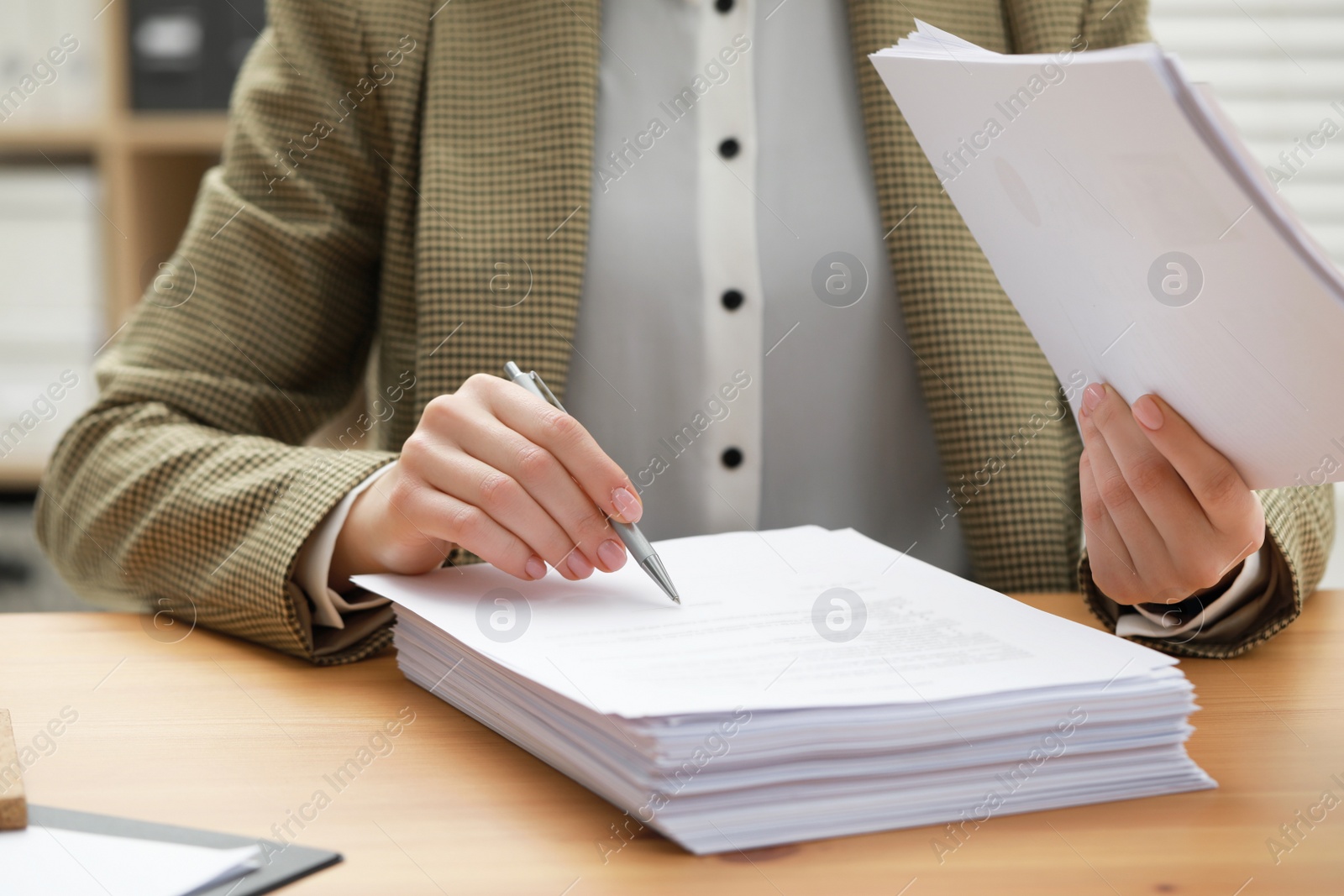 Photo of Woman signing documents at table in office, closeup