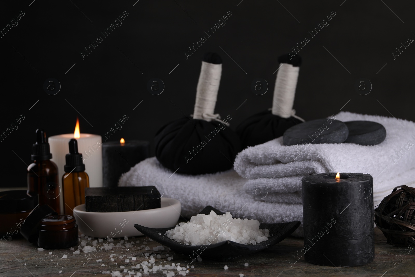Photo of Composition with different spa products and burning candles on grey textured table