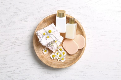 Photo of Composition with chamomile flowers and cosmetic products on white table, top view