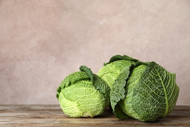 Fresh green savoy cabbages on wooden table. Space for text