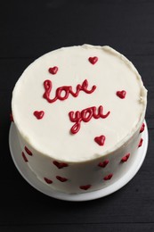 Bento cake with text Love You on black wooden table, closeup. St. Valentine's day surprise