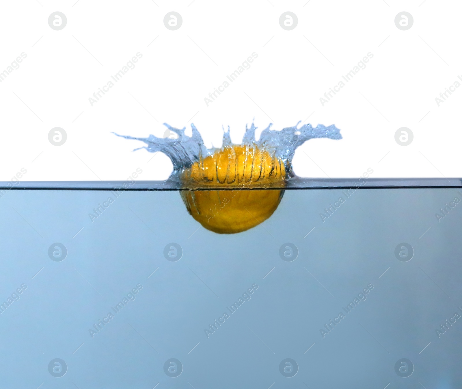 Photo of Ripe lemon falling down into clear water with splashes against white background