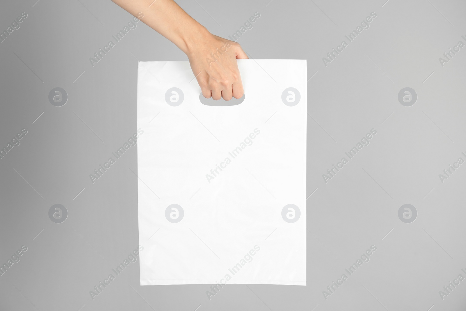 Photo of Woman with plastic bag on grey background. Mock up for design