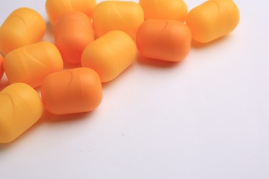 Photo of Sveti Vlas, Bulgaria - June 30, , 2023: Orange plastic capsules from Kinder Surprise Eggs on white background, closeup
