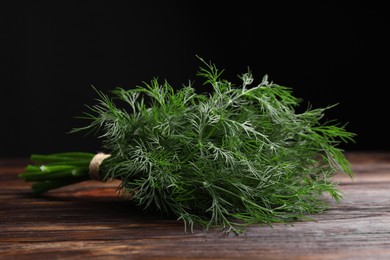 Photo of Bunch of fresh dill on wooden table, closeup