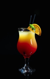 Photo of Glass of delicious cocktail Sex on the Beach decorated with orange and mint against black background