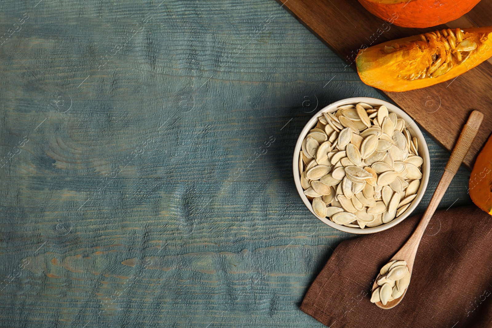 Photo of Flat lay composition with raw pumpkin seeds on blue wooden table, space for text