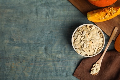 Photo of Flat lay composition with raw pumpkin seeds on blue wooden table, space for text