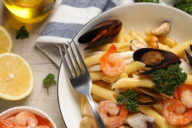 Delicious pasta with sea food served on white wooden table, flat lay