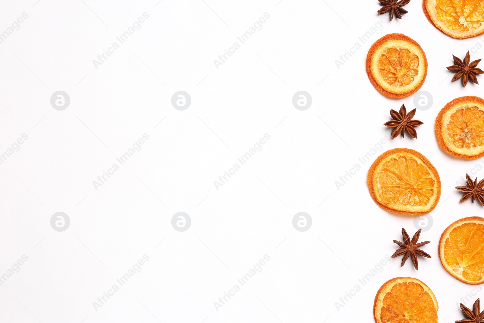 Photo of Dry orange slices and anise stars on white background, flat lay. Space for text