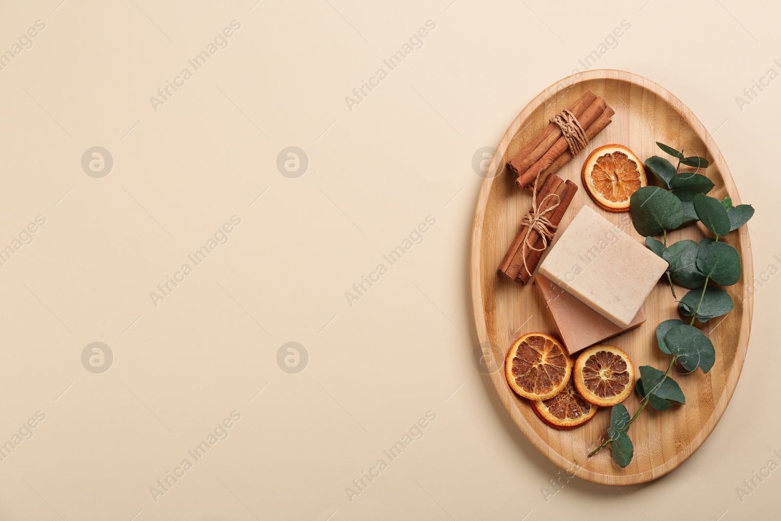 Photo of Natural handmade soap and ingredients on beige background, top view. Space for text