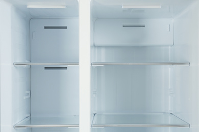 Shelves of empty modern refrigerator, closeup view