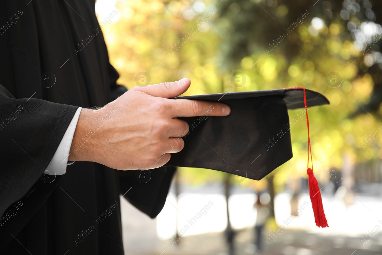 Photo of Student with graduation hat outdoors on sunny day, closeup