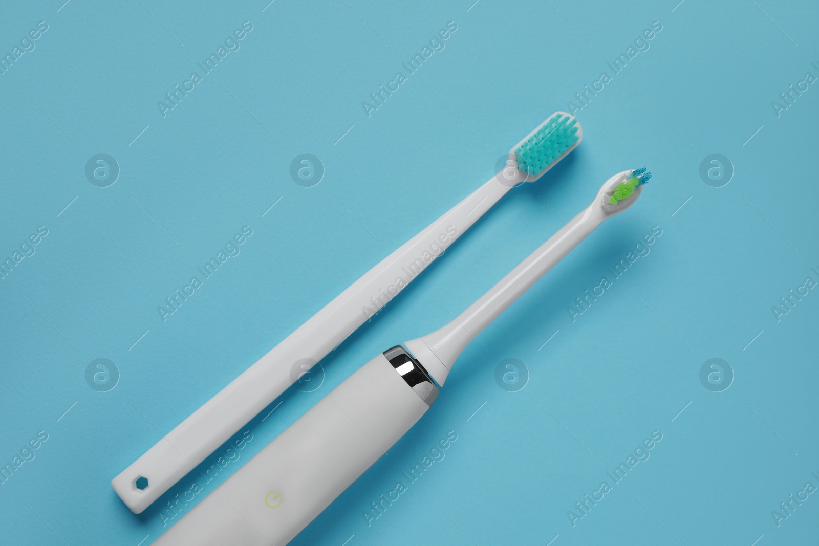 Photo of Electric and plastic toothbrushes on turquoise background, flat lay