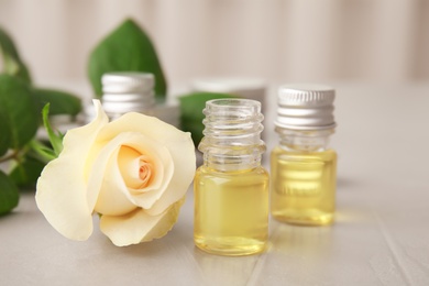 Photo of Composition with essential oil and flower on table