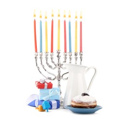 Photo of Hanukkah celebration. Menorah with candles, gift boxes, donut, colorful dreidels and jug isolated on white