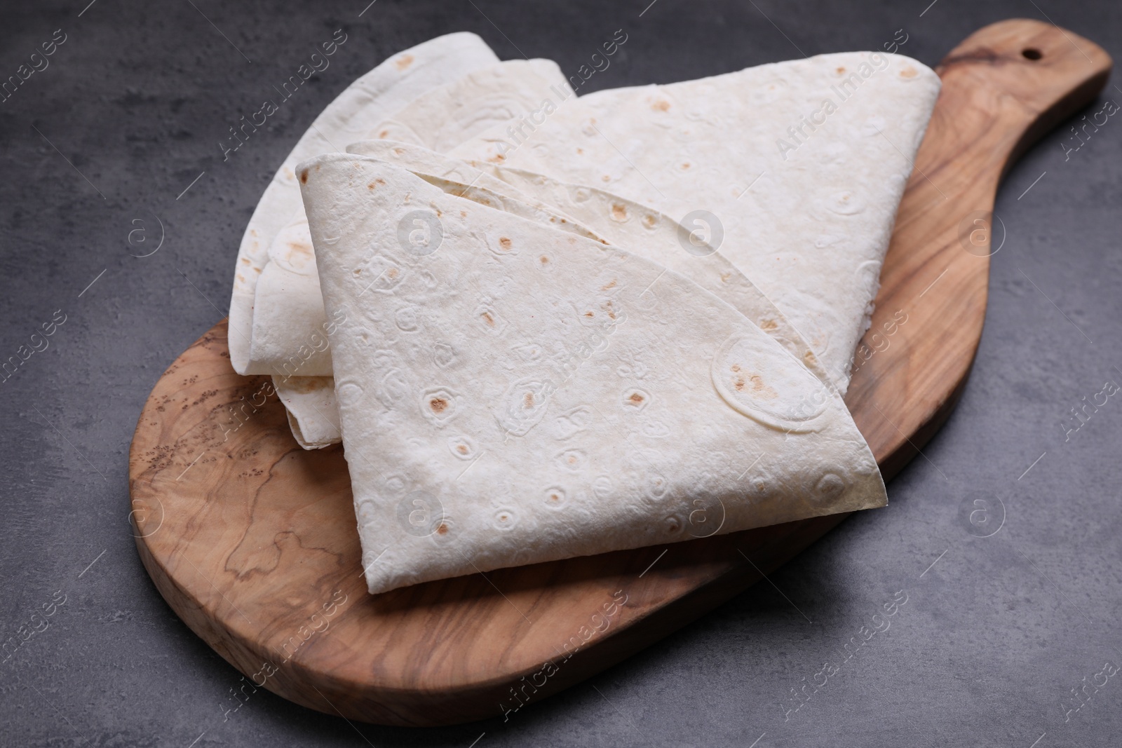 Photo of Delicious folded Armenian lavash on dark table