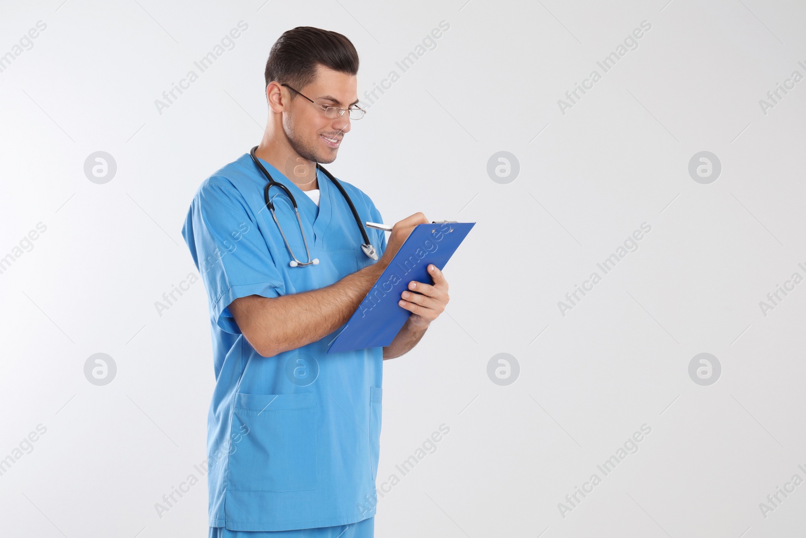 Photo of Doctor with stethoscope and clipboard on light grey background. Space for text