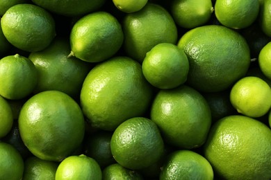 Photo of Fresh ripe green limes as background, top view