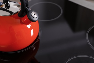 Photo of Modern kettle with whistle on stove, closeup. Space for text