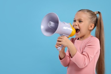 Photo of Special promotion. Little girl with megaphone on light blue background. Space for text