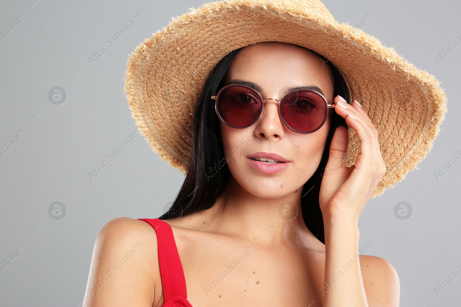 Photo of Beautiful woman wearing sunglasses on grey background