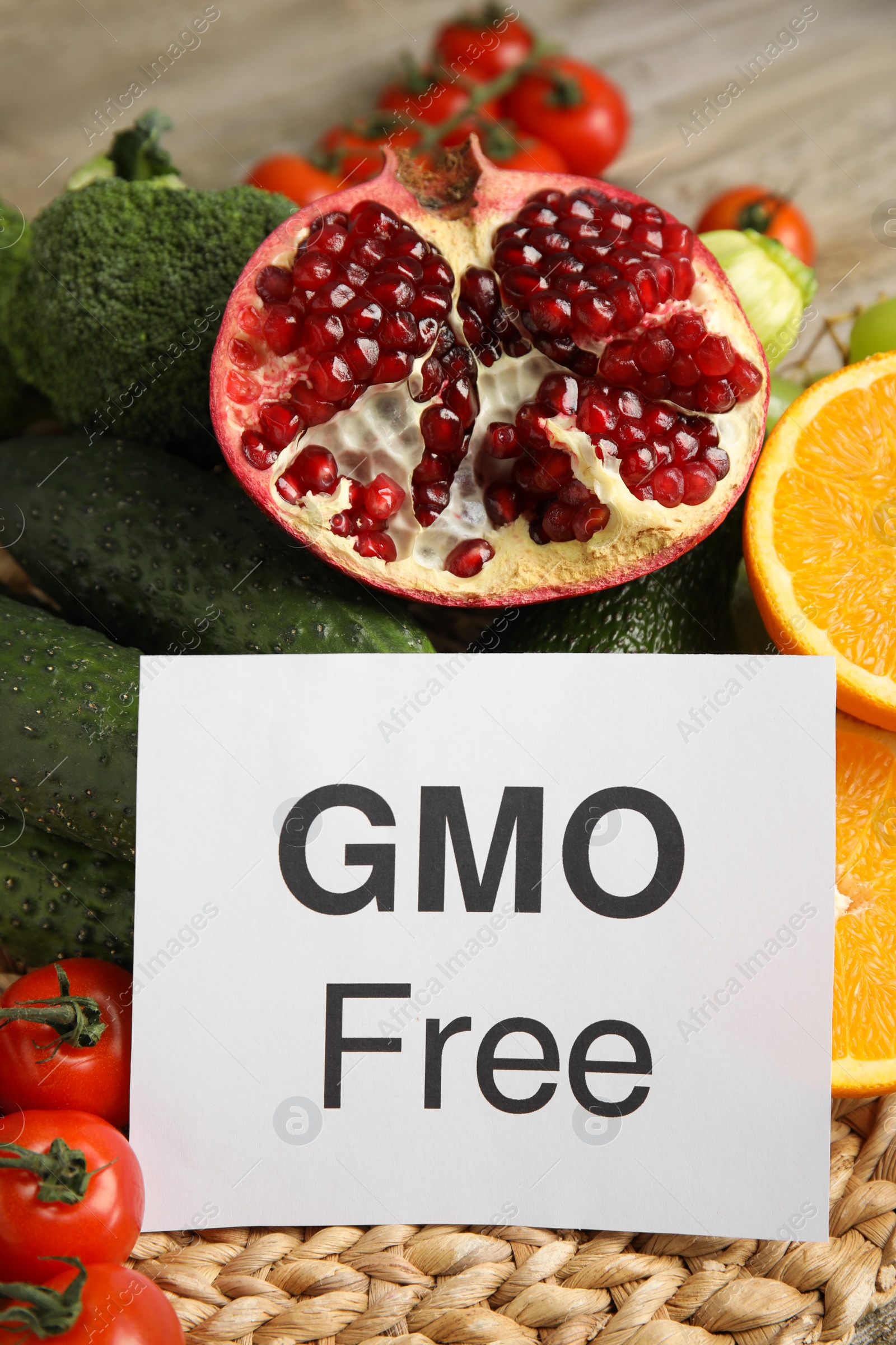 Photo of Tasty fresh GMO free products and paper card on wooden table