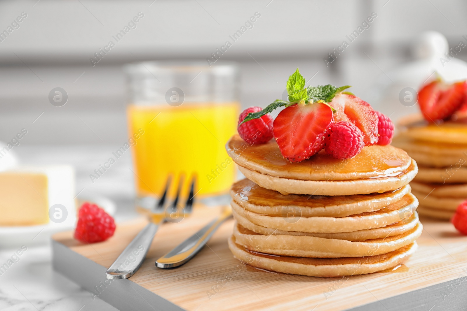 Photo of Tasty pancakes with berries on wooden board