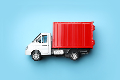 Photo of Top view of toy truck on blue background, space for text. Logistics and wholesale concept