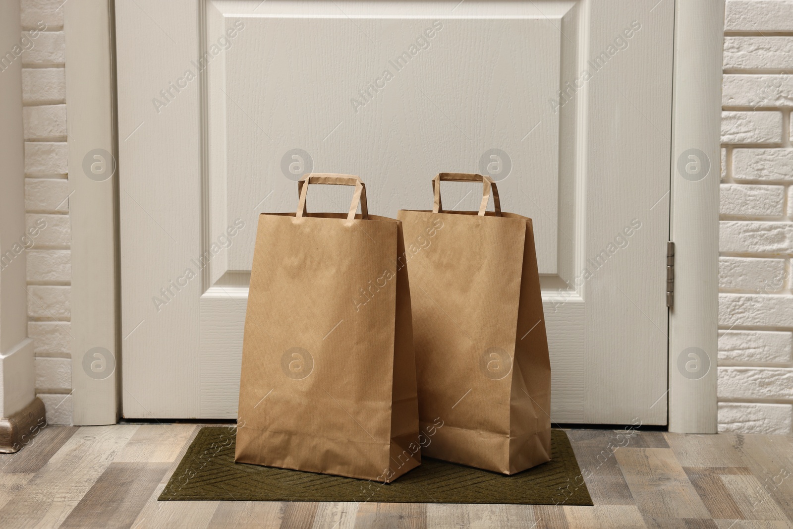 Photo of Paper bags on door mat near entrance indoors