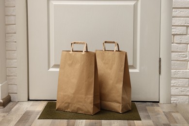 Paper bags on door mat near entrance indoors