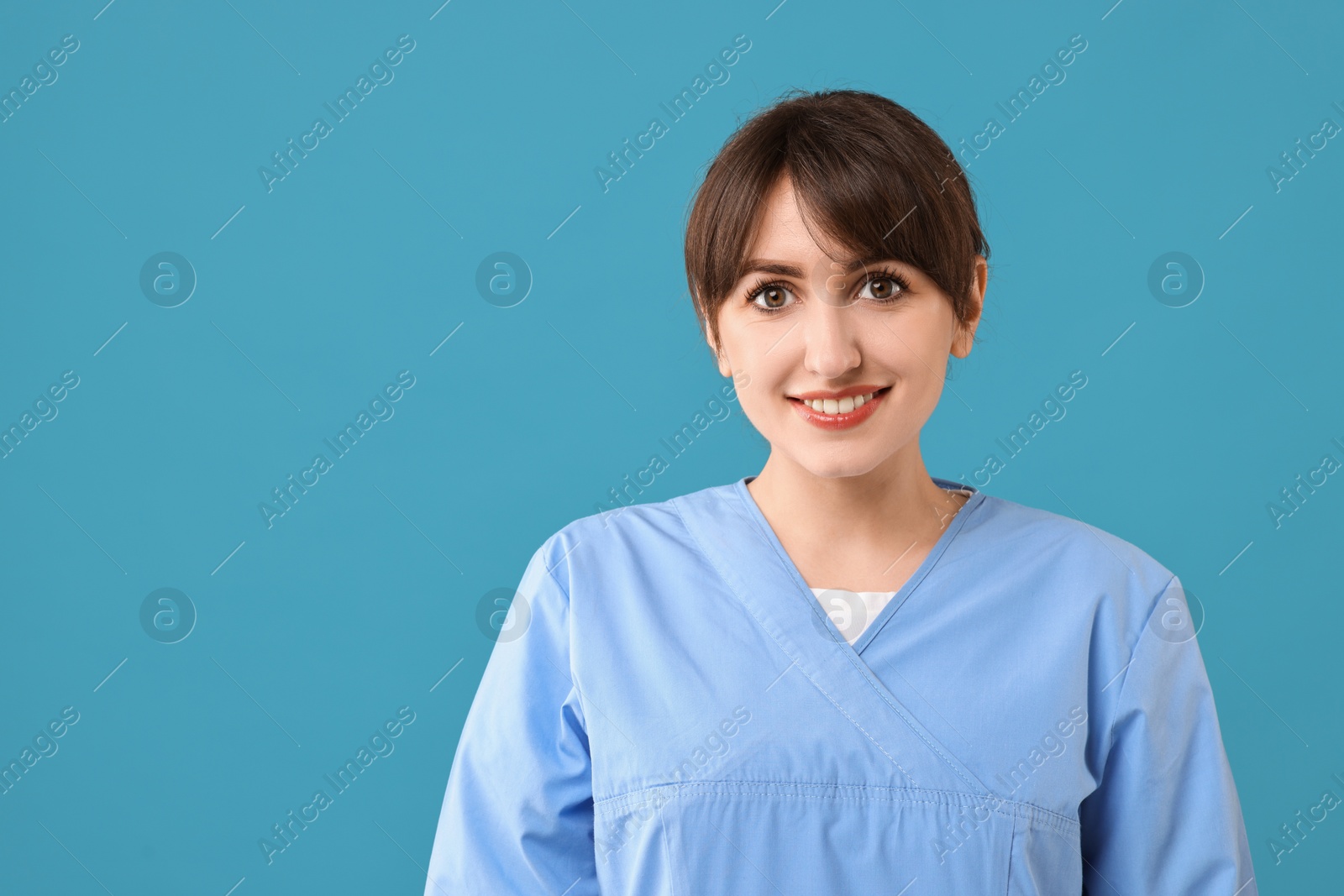 Photo of Portrait of smiling medical assistant on light blue background. Space for text