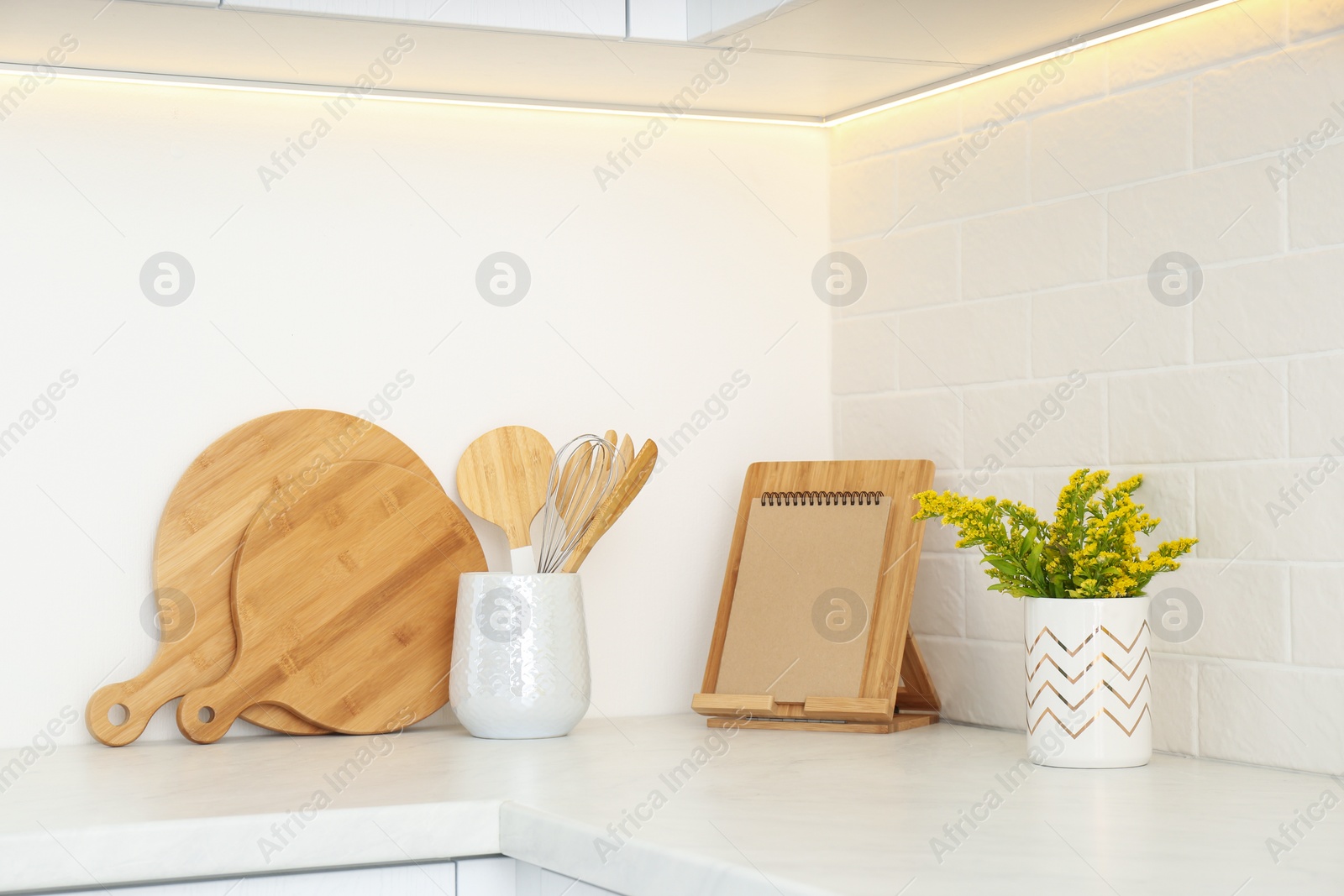 Photo of Wooden kitchenware and mimosa flowers on countertop indoors