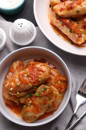 Photo of Delicious stuffed cabbage rolls cooked with homemade tomato sauce on table, flat lay