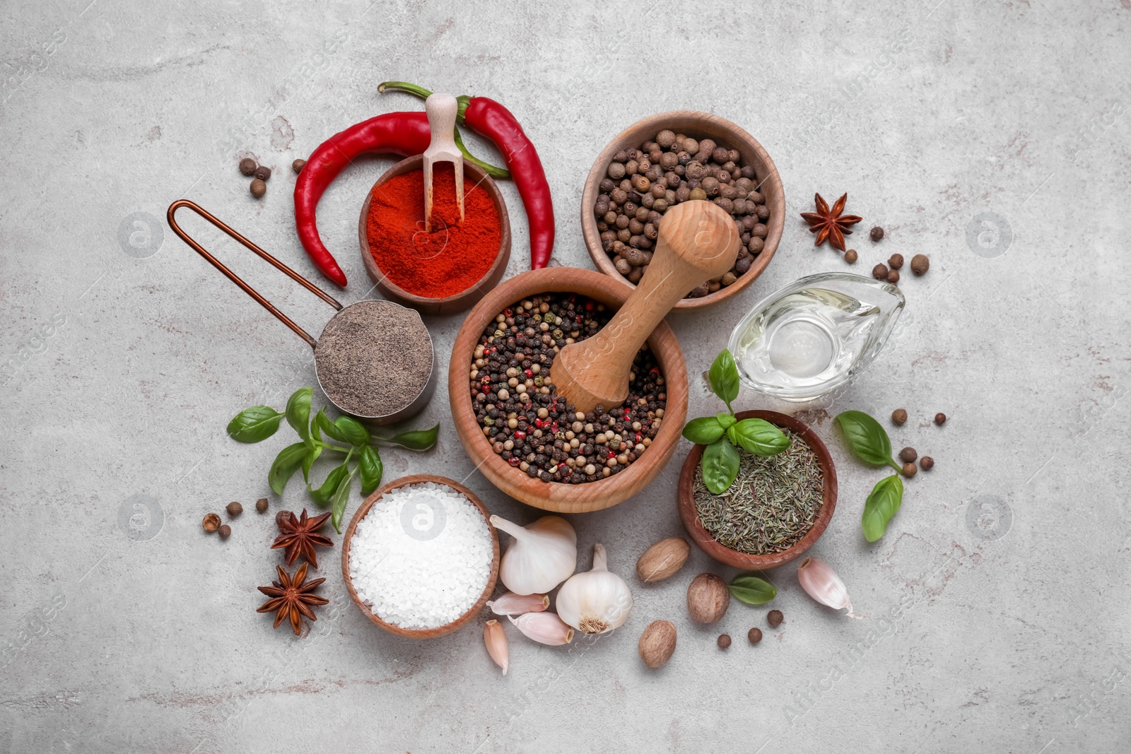 Photo of Mortar with different spices on grey table, flat lay