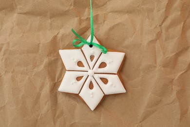 Photo of Snowflake shaped Christmas cookie on parchment, top view