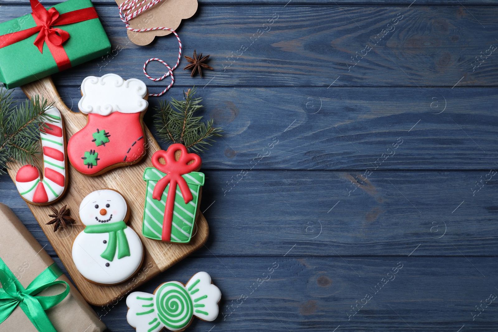 Photo of Decorated Christmas cookies on blue wooden table, flat lay. Space for text