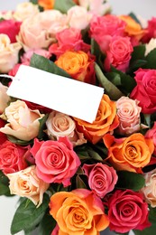 Bouquet of beautiful roses with blank card, closeup