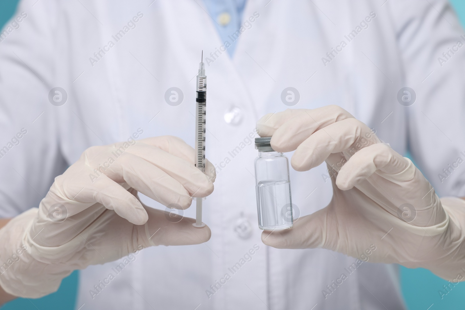 Photo of Doctor holding syringe and glass vial, closeup view