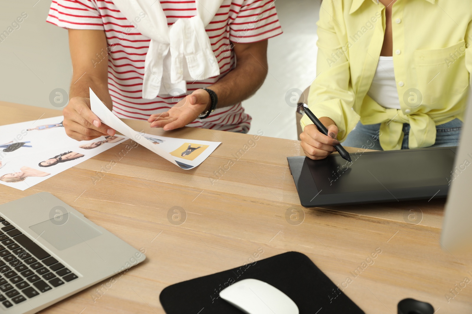 Photo of Professional retoucher with colleague working at desk in office, closeup