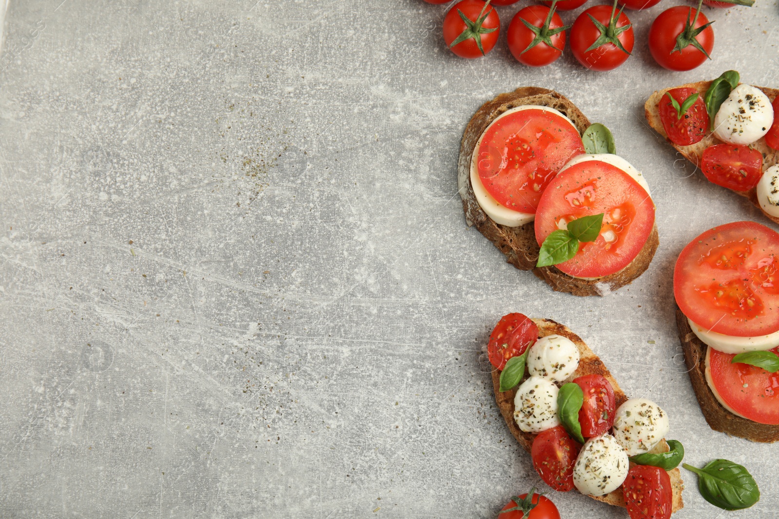 Photo of Delicious sandwiches with mozzarella, fresh tomatoes and basil on light grey table, flat lay. Space for text