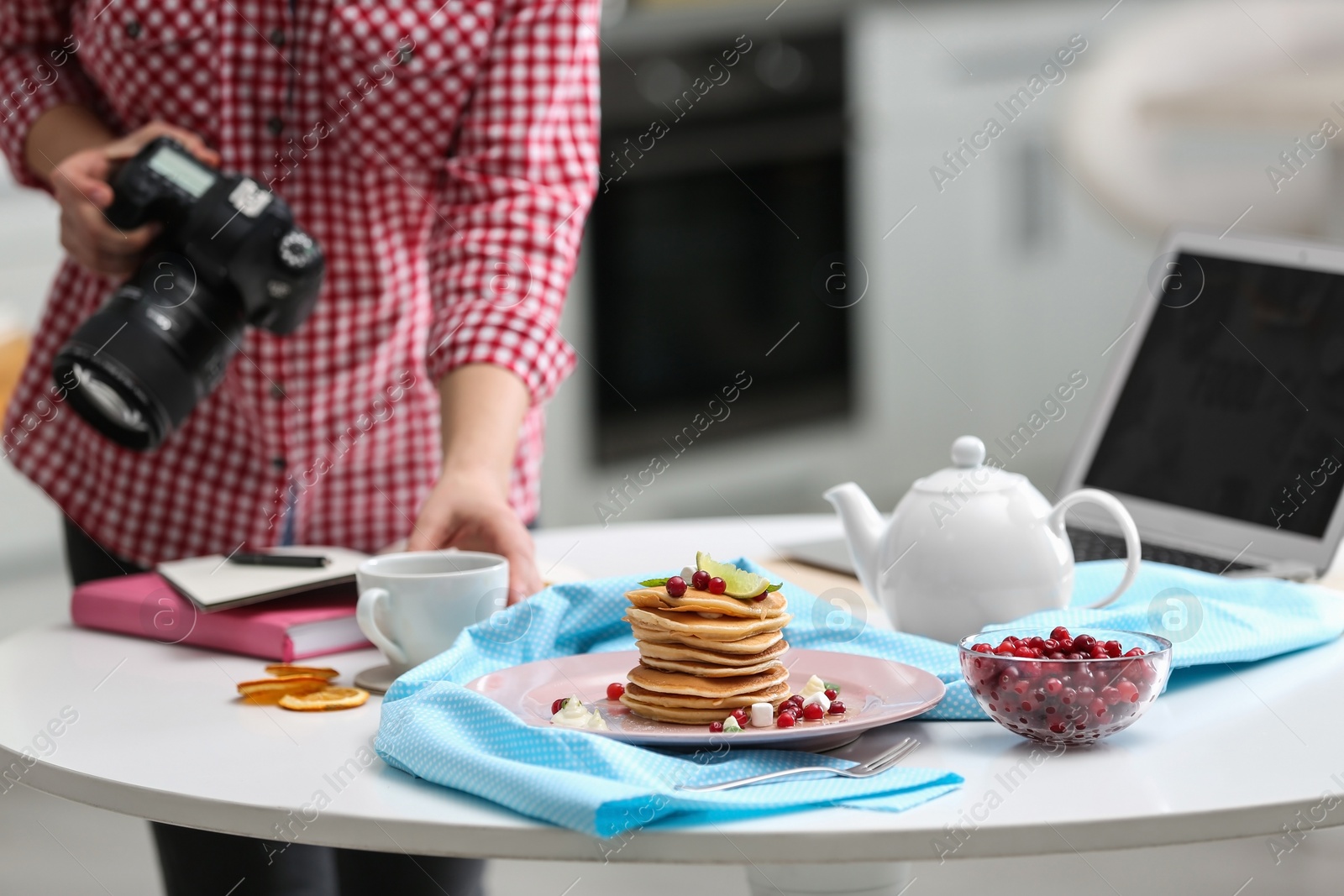 Photo of Food blogger taking photo of her breakfast at table, closeup