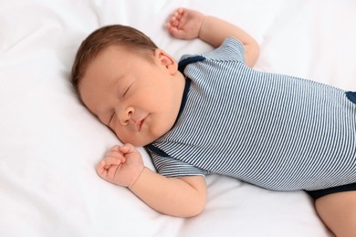 Cute newborn baby sleeping on white soft bed