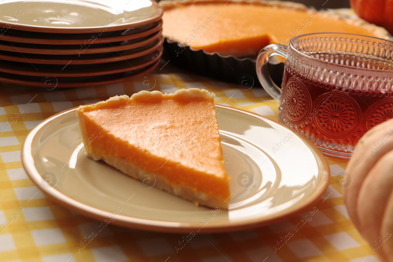 Photo of Piece of fresh homemade pumpkin pie served with tea on table